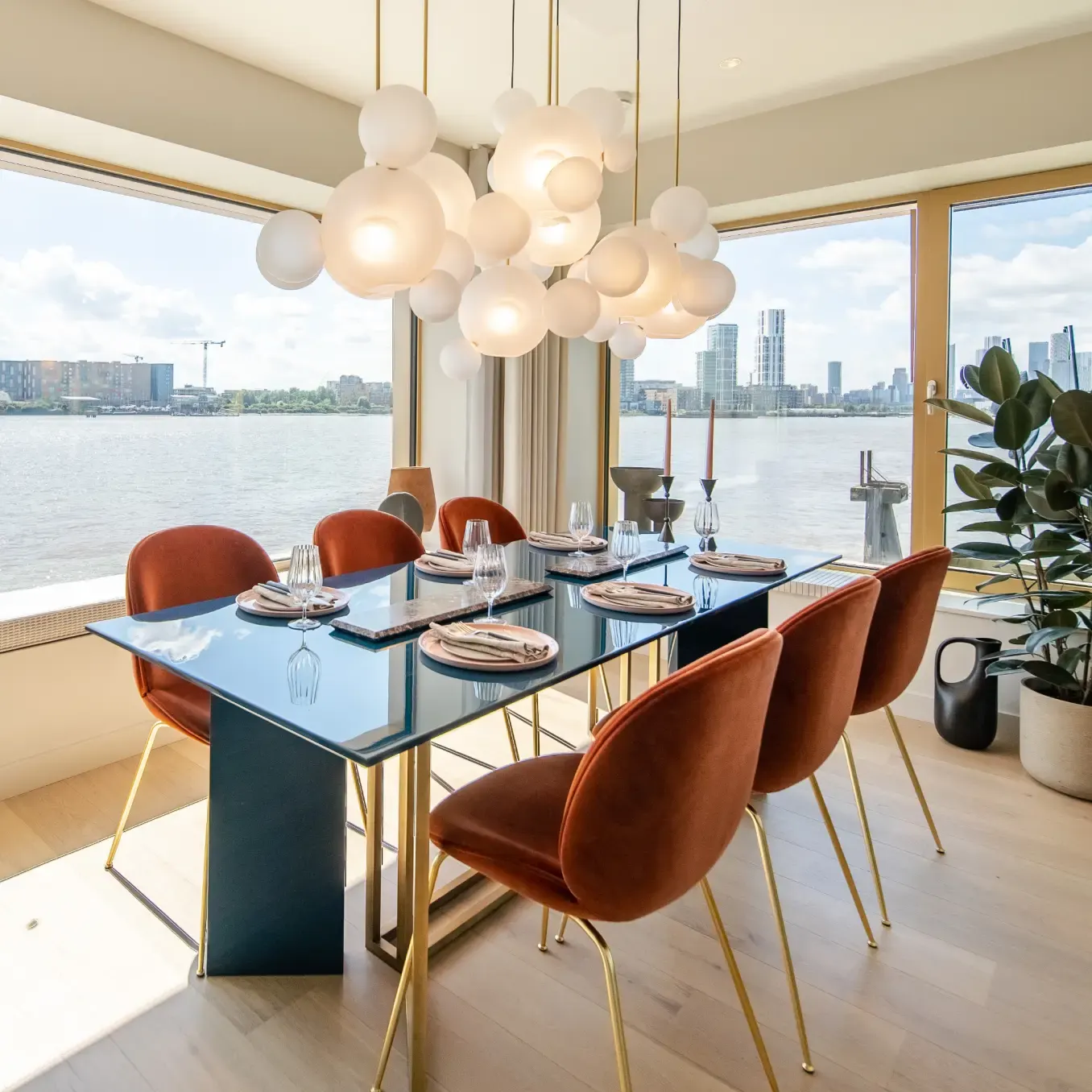 Dining table set beneath a cluster of glass pendant lights